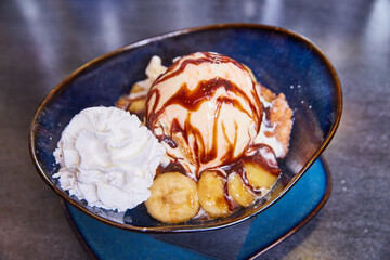 Gourmet Banana Split in Blue Bowl with Caramelized Bananas and Chocolate Syrup