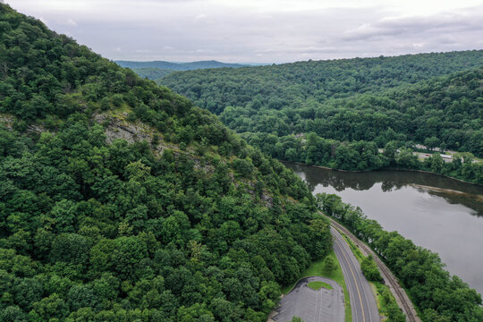 Aerial Drone View of a road along the Delaware River among the mountains in Poconos, Pennsylvania, United States.