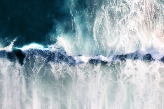 Aerial view of a blue ocean wave breaking, with white foam and a motion blue effect, Cape Town, Western Cape, South Africa.