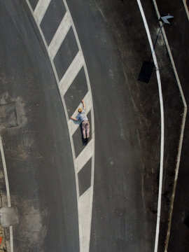 Aerial view of a person laying down on the ground climbing road sign, Spinetta, Marengo, Piedmont, Italy.