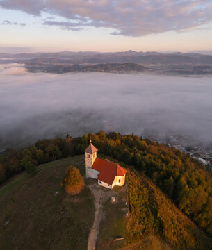 Aerial drone view of Cerkev sv. Ane church on hill at Jezero, Brezovica, Slovenia.