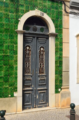 Puerta rodeada de azulejos verdes en São Brás de Alportel, Algarve, Portugal