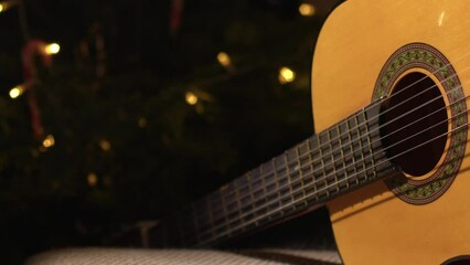 Accoustic guitar in front of Christmas tree 