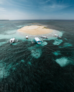 Aerial drone view of long tail touristic boats docked along the naked island Siargao, Surigao del Norte, Philippines.