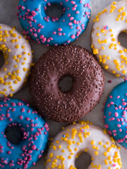 Sweet colorful donuts with a various sprinkles. Fat Thursday celebration. Flat lay.