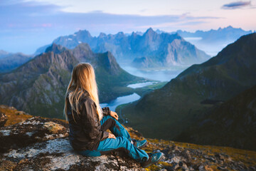 Solo traveler enjoying landscape in Norway Lofoten islands aerial view woman traveling outdoor relaxing on the top of mountain alone healthy lifestyle summer vacations adventure trip - obrazy, fototapety, plakaty