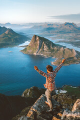 Man tourist traveling in Norway alone enjoying aerial sea view hiking in mountains outdoor traveler raised hands healthy lifestyle adventure vacations exploring Lofoten islands - 741702401