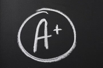 School grade. Letter A with plus symbol on blackboard, closeup