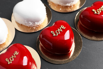Obraz na płótnie Canvas St. Valentine's Day. Delicious heart shaped cakes on black table, closeup