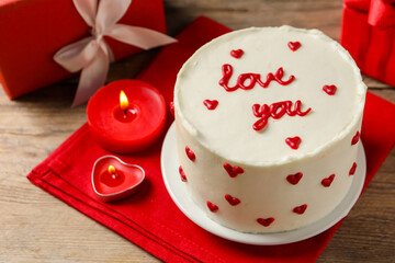 Bento cake with text Love You, candles and gift boxes on wooden table. St. Valentine's day surprise