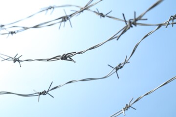 Fototapeta na wymiar Metal barbed wire on light blue background