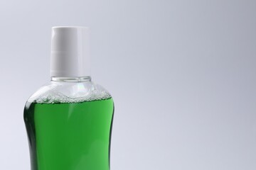 Fresh mouthwash in bottle on grey background, closeup. Space for text