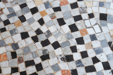 Irregular ancient mosaic pattern with different sorts of marble in a street in Rome, Italy. Abstract background
