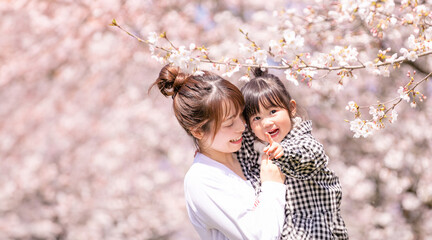 満開の桜を見る笑顔の親子