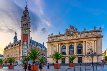 Lille Chamber of Commerce and Opera de Lille opera house theatre neo-classical, palms trees in wooden flowerbed on Place du Theatre square in historical center in the evening, French Flanders, France