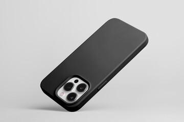 iPhone 15 Pro in black soft silicone case falls down back view, smartphone mockup isolated on grey background
