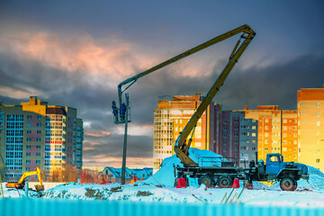 Mobile construction crane with telescopic boom at the construction site in the city lifts a lever...