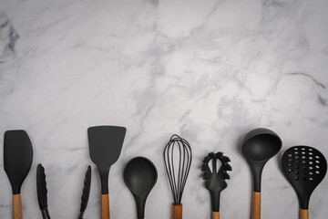 Kitchen silicone utensils for cooking tools on white marble background, top view, flat lay....