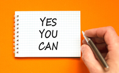 Motivational Yes you can symbol. Concept words Yes you can on beautiful white note. Beautiful orange background. Businessman hand. Business motivational and Yes you can concept. Copy space