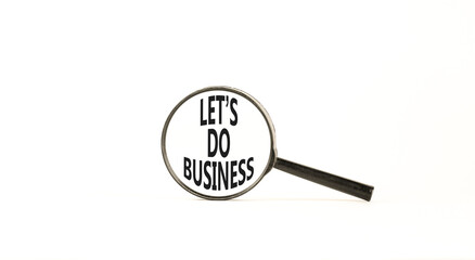 let is do business symbol. Concept words let is do business in beautiful magnifying glass. Beautiful white table white background. let is do business concept. Copy space.