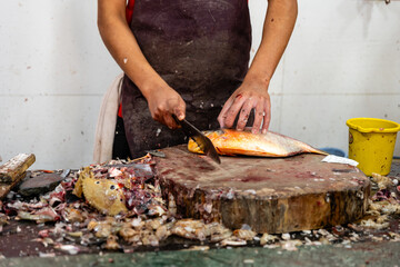 Cutting fish with a knife on a chopping board in a restaurant