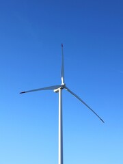 Windmill to generate energy. Wind turbine and a blue sky.