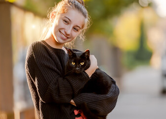Teenage Girl Holds Black Cat In Her Hands, A Portrait With A Pet At Home - 741747433