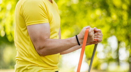 Man'S Hands With Sports Bands Pump Biceps In Close-Up Outdoor Sports