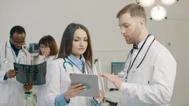 Group of doctors examining medical images on tablet