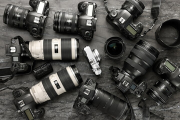 Modern cameras on dark gray marble table, flat lay