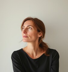 Fototapeta premium A girl in a black top with a languid face against a neutral background. Minimalist portrait.