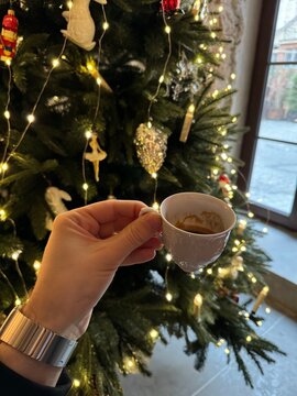 cup of coffee in hand and Christmas tree