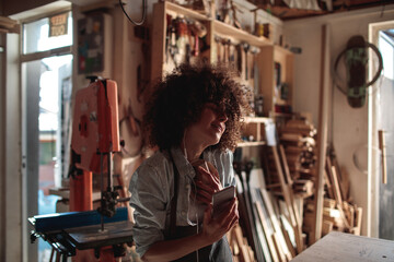 Fototapeta na wymiar Woman listening to music in a woodworking workshop