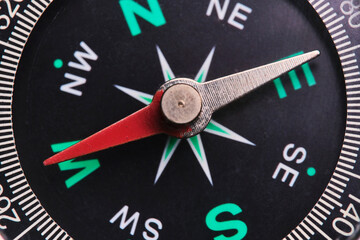 Dial compass in closeup, arrow indicates direction west.