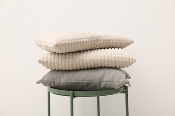 Soft pillows on side table near beige wall