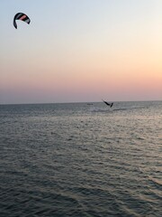 kite surfing in the sea at sunset