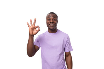 close-up portrait of a young laughing african man in a lilac t-shirt making a grimace