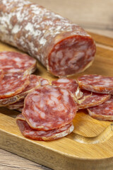 saucisson sec tranché, en gros plan, sur une planche à découper