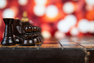 black chess pieces with bokeh lights in the background. Symbolizing strategy and rivalry.