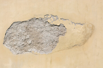 Damage and peeling of plaster on the wall under the influence of atmospheric precipitation. For use as an abstract background and texture.