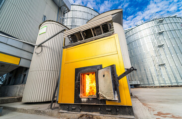 Small yellow wood-burning stove is heated by modern biomass boiler