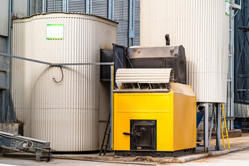 Yellow industrial boiler and silos in the factory