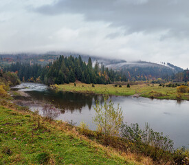 Foggy and overcast autumn day in Carpathian Mountains. Rika river bend, Transcarpathia, Ukraine.