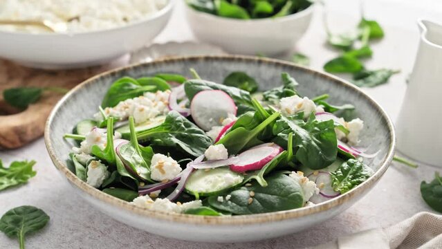 Spinach and cottage cheese fresh green vegetable salad with radish, cucumber and yogurt, stock footage video 4k