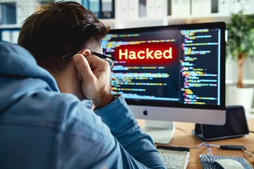 Foto op Plexiglas office worker at their computer after finding out he has been hacked in a cyber security attack © StockUp
