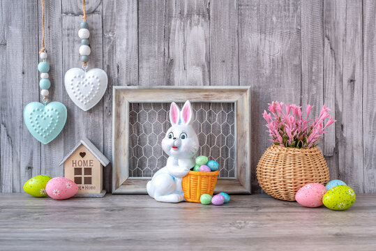 The Easter decorative rabbit is decorated with colored eggs in the Provence style. Easter decorations. Happy Easter. Grey background.