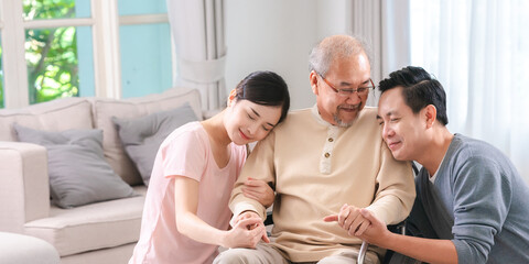 Happy elder Asian man using wheelchair while exercise indoor house with his son taking care of him at the retirement age with copy space - obrazy, fototapety, plakaty