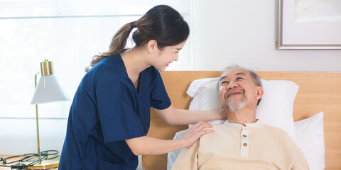 Young asian female nurse care giver helping asian senior old man in living area of nursing home...