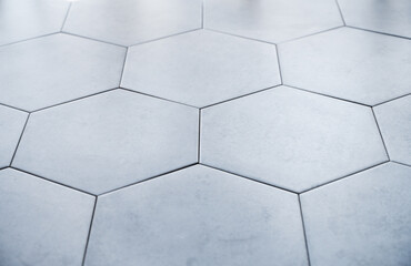 Background of gray hexagon shaped ceramic tiles. Trendy empty backdrop for displaying products or...