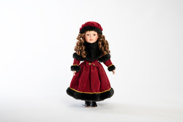 Beautiful doll in a red dress and hat. On a white background